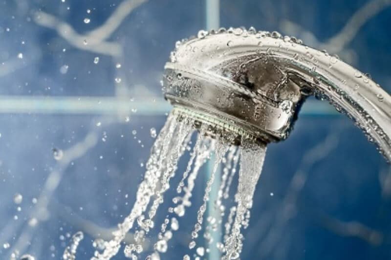 Water-efficient tap with green foliage nearby