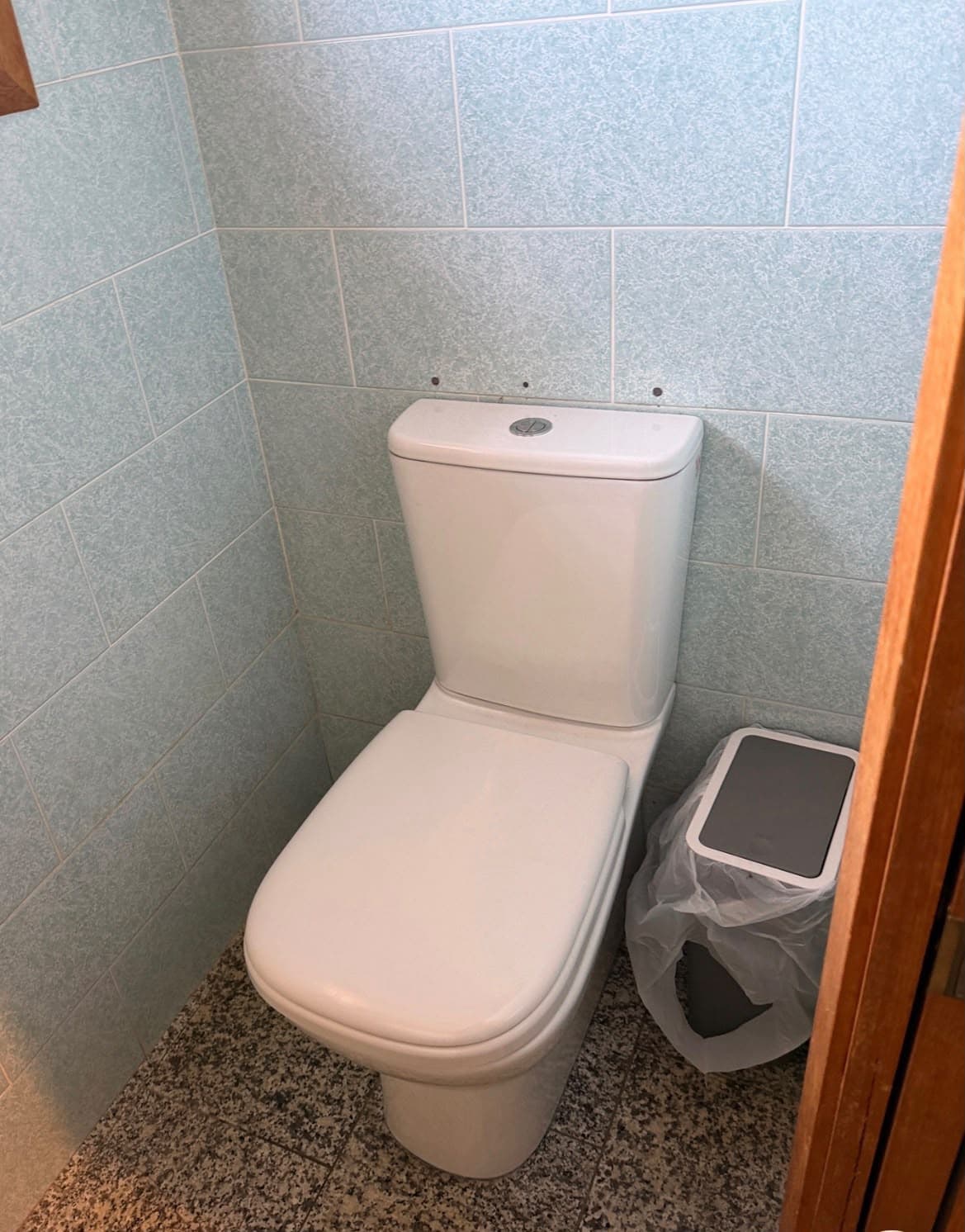 White close-coupled toilet in a tiled bathroom