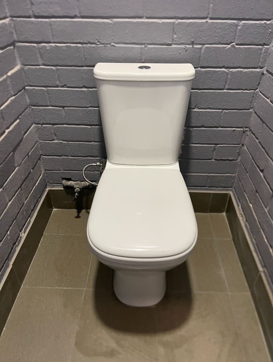 Close-coupled toilet with a side water connection