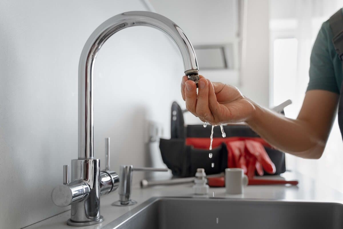 Plumber repairing a dripping tap in a Moorebank kitchen